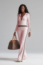 Ensemble sportswear côtelé Black-Coat avec zip et bandes latérales - angle diagonal dynamique d'une mannequin en pose confiante sur fond blanc studio, capturant le style athleisure moderne, la maille côtelée texturée, les bandes latérales contrastées et la silhouette urbaine chic