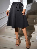 Jupe mi-longue à détail noué - vue de profil révélant le tombé fluide du polyester premium et la coupe élégante - BLACK-COAT
