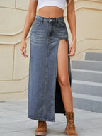 Jupe longue denim boutonnée BLACK-COAT vue de face - silhouette sophistiquée avec boutonnage frontal élégant, découpes modernes stratégiques, fentes latérales et poches fonctionnelles - tissu rayonne-polyester au tombé fluide noble - longueur maxi flatteuse qui transforme le denim classique en pièce statement raffinée accessible
