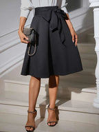 Jupe mi-longue à détail noué - gros plan sur le détail noué féminin qui ajoute du caractère à la silhouette - BLACK-COAT
