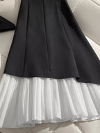 "Jupe noire plissée BLACK-COAT - vue arrière illustrant la coupe structurée et l'élégance intemporelle du design"