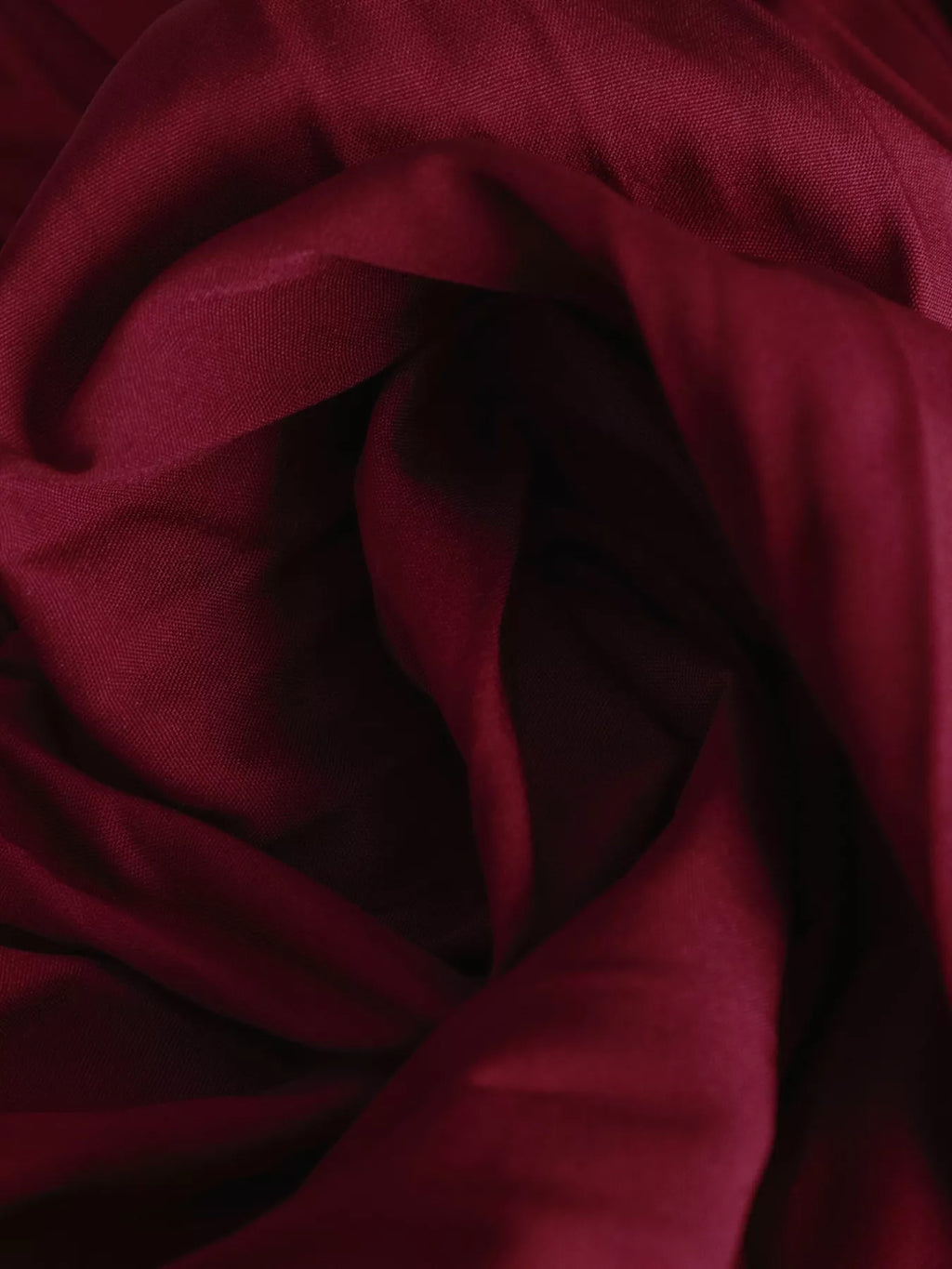 Gros plan détail plis de la jupe midi, texture plissée permanente, qualité du tissu, finitions soignées
