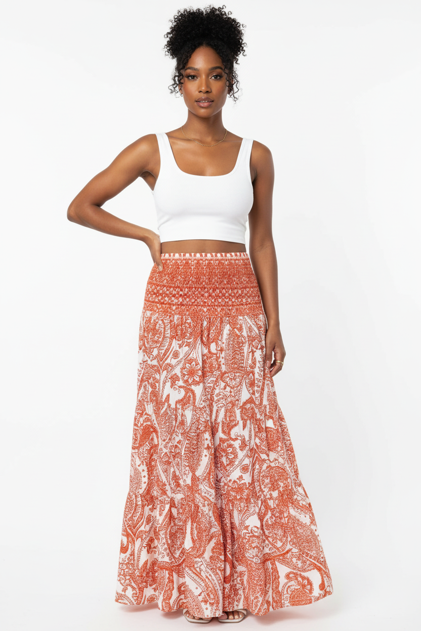 Jupe longue bohème Black-Coat à imprimé paisley avec taille smockée et volants étagés - vue corps entier d'une mannequin avec main sur la hanche en pose confiante sur fond blanc studio, illustrant la silhouette bohème romantique, la longueur maxi flatteuse, la taille smockée confortable et l'attitude décontractée et élégante que procure cette jupe