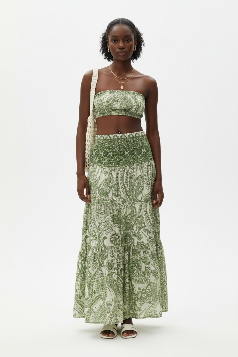 Jupe longue bohème Black-Coat verte et blanche à imprimé paisley avec taille smockée et volants étagés - vue de face frontale complète d'une mannequin en pose debout sur fond blanc studio, présentant la taille smockée ultra-confortable, l'imprimé paisley vert et blanc sophistiqué, les volants étagés et la longueur maxi fluide et bohème