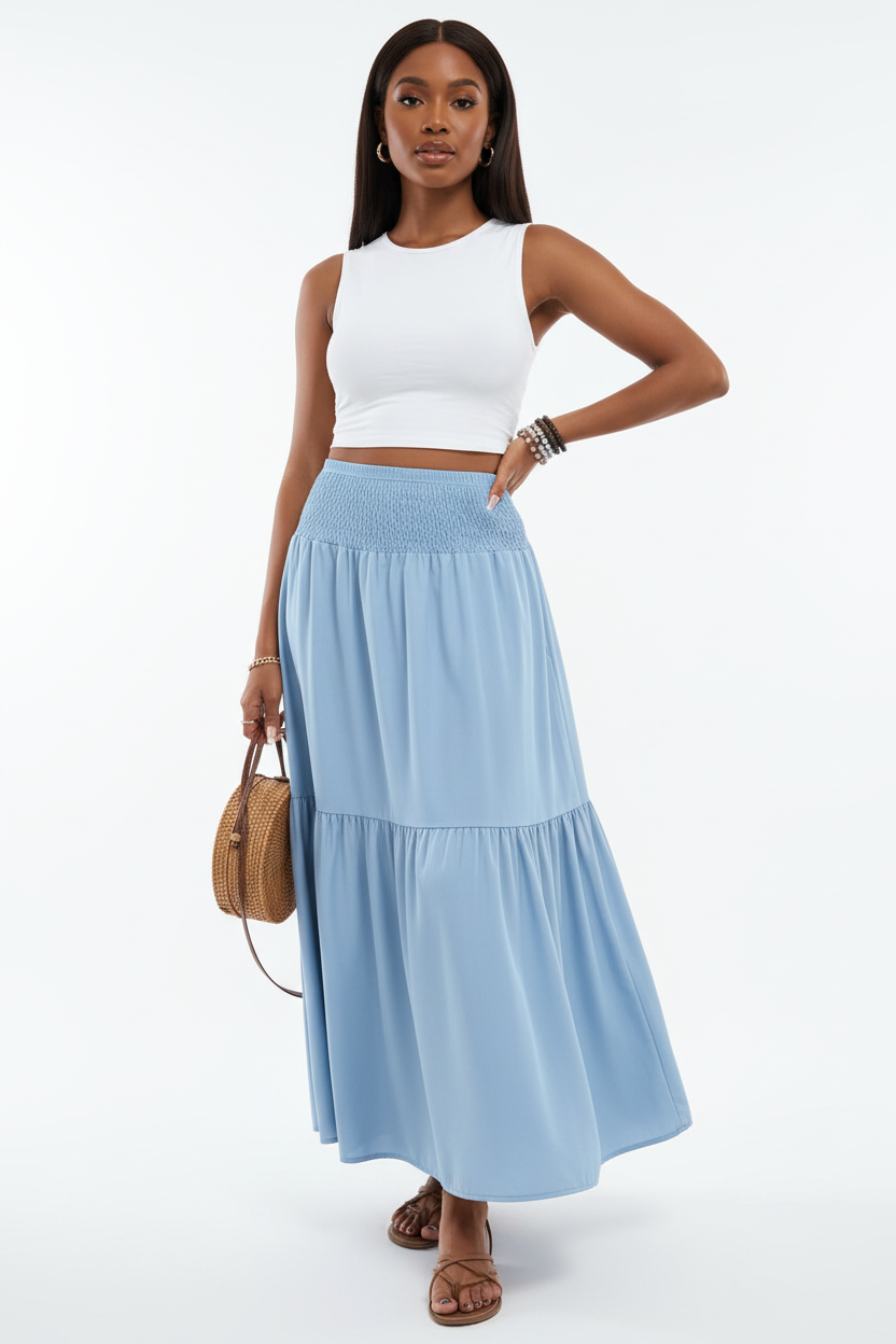 Jupe longue smockée à volants Black-Coat - vue corps entier d'une mannequin avec main sur la hanche en pose confiante sur fond blanc studio, illustrant la silhouette minimaliste chic, la longueur maxi flatteuse, le volant étagé romantique et l'attitude décontractée et élégante que procure cette jupe