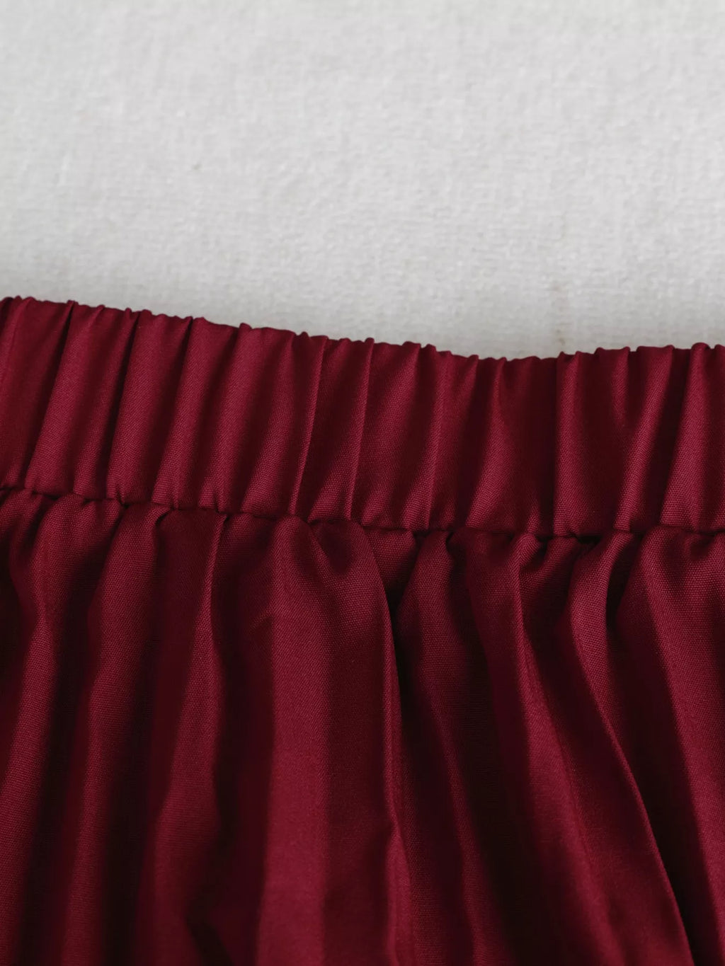 Jupe midi plissée portée en mouvement, plis fluides en action, silhouette féminine élégante
