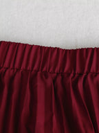 Jupe midi plissée portée en mouvement, plis fluides en action, silhouette féminine élégante
