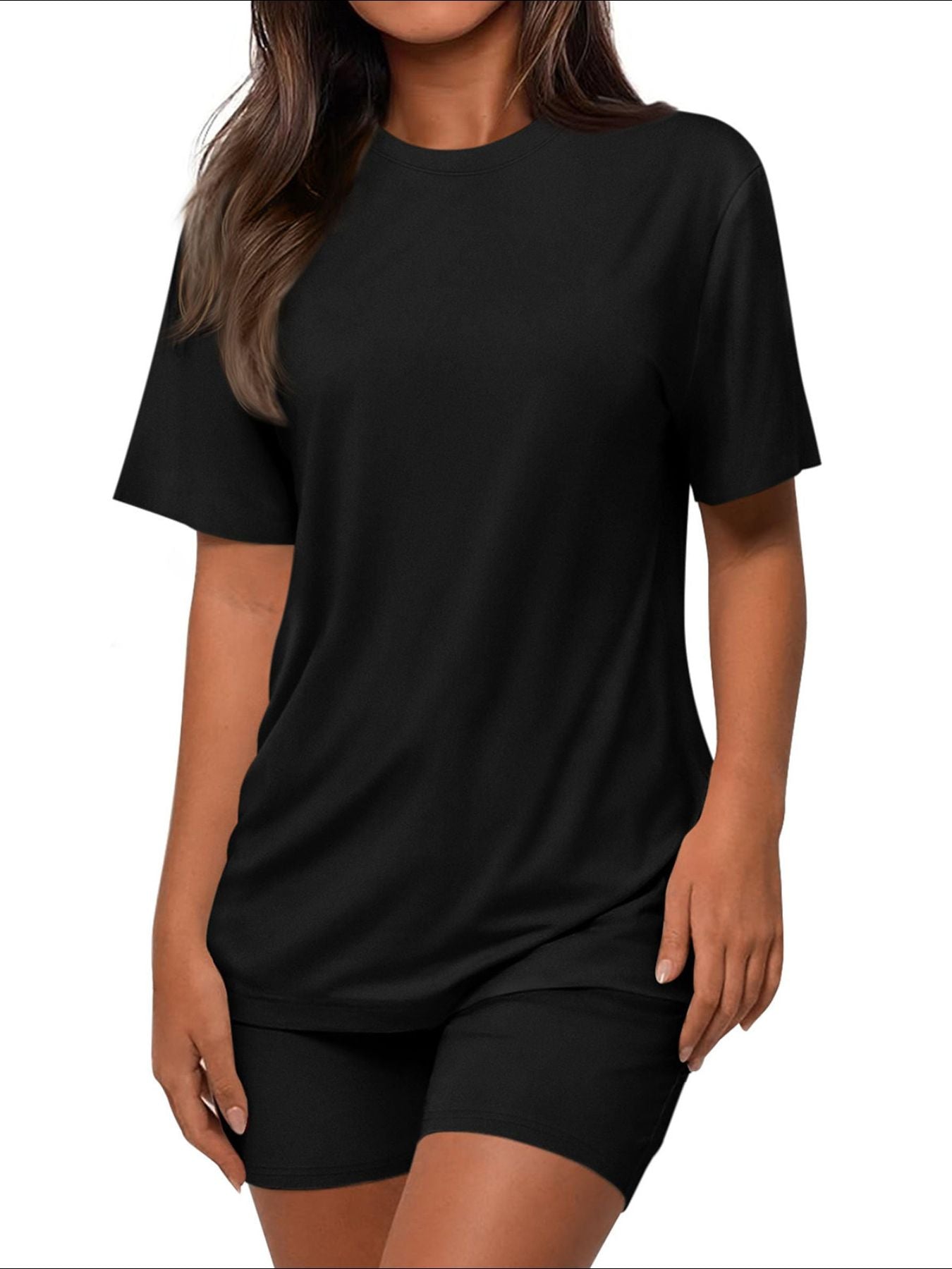 Mannequin en pleine foulée portant l'ensemble coordonné t-shirt oversize et short cycliste noir Black-Coat, vue en contre-plongée dynamique — effet de puissance et d'assurance absolue, silhouette allongée et magnifiée par l'angle dramatique, t-shirt oversize col rond au tombé parfait, manches courtes structurées, short cycliste gainant et confortable, coloris noir intemporel et indémodable sublimant chaque silhouette, fond blanc immaculé, éclairage naturel dramatique, photographie mode éditoriale Black-Coat