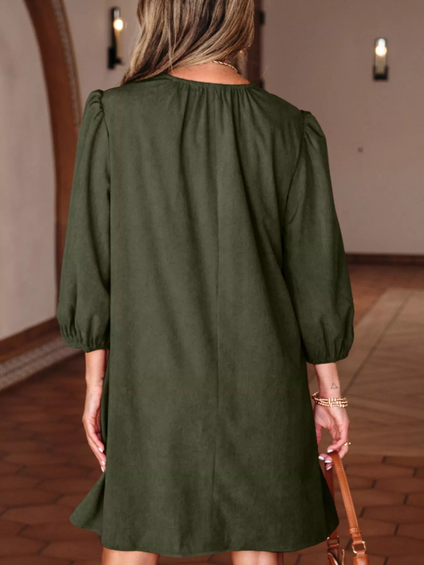 Vue arrière dos mini robe velours côtelé plissé, manches bracelet visibles de dos, détails festonnés à l'arrière, texture côtelée plissée, longueur mini, style vintage élégant de dos
