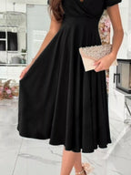 Détail encolure cache-cœur de la robe midi BLACK-COAT - gros plan sur la ligne en V flatteuse, montrant la qualité du tissu coton-élasthanne et la finition soignée de cette pièce estivale élégante
