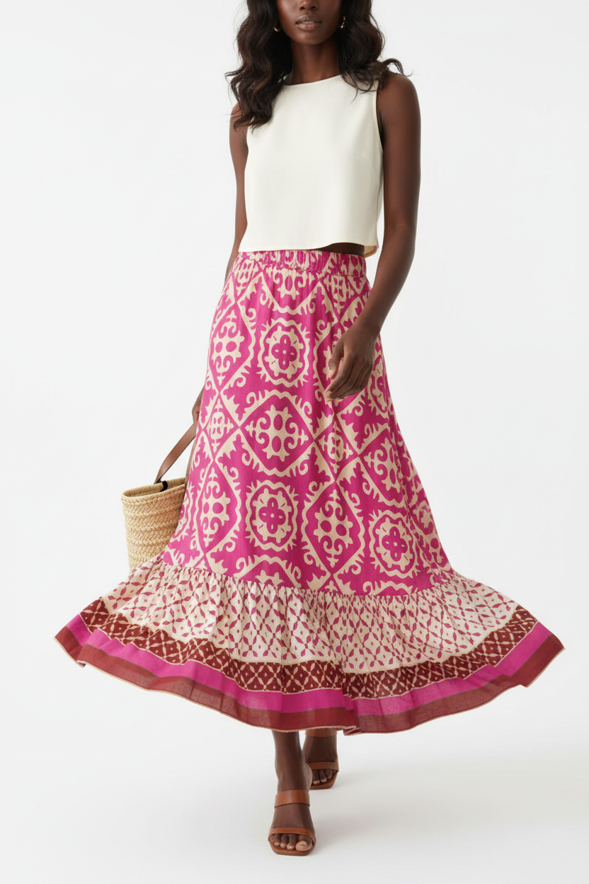Jupe longue bohème Black-Coat rose et beige à imprimé géométrique avec volants étagés et bordure contrastée - mannequin capturée en pleine marche sur fond blanc studio, montrant le mouvement naturel et fluide des volants étagés, la façon dont la jupe ondule avec grâce, l'élégance bohème en mouvement et le tombé parfait du tissu léger