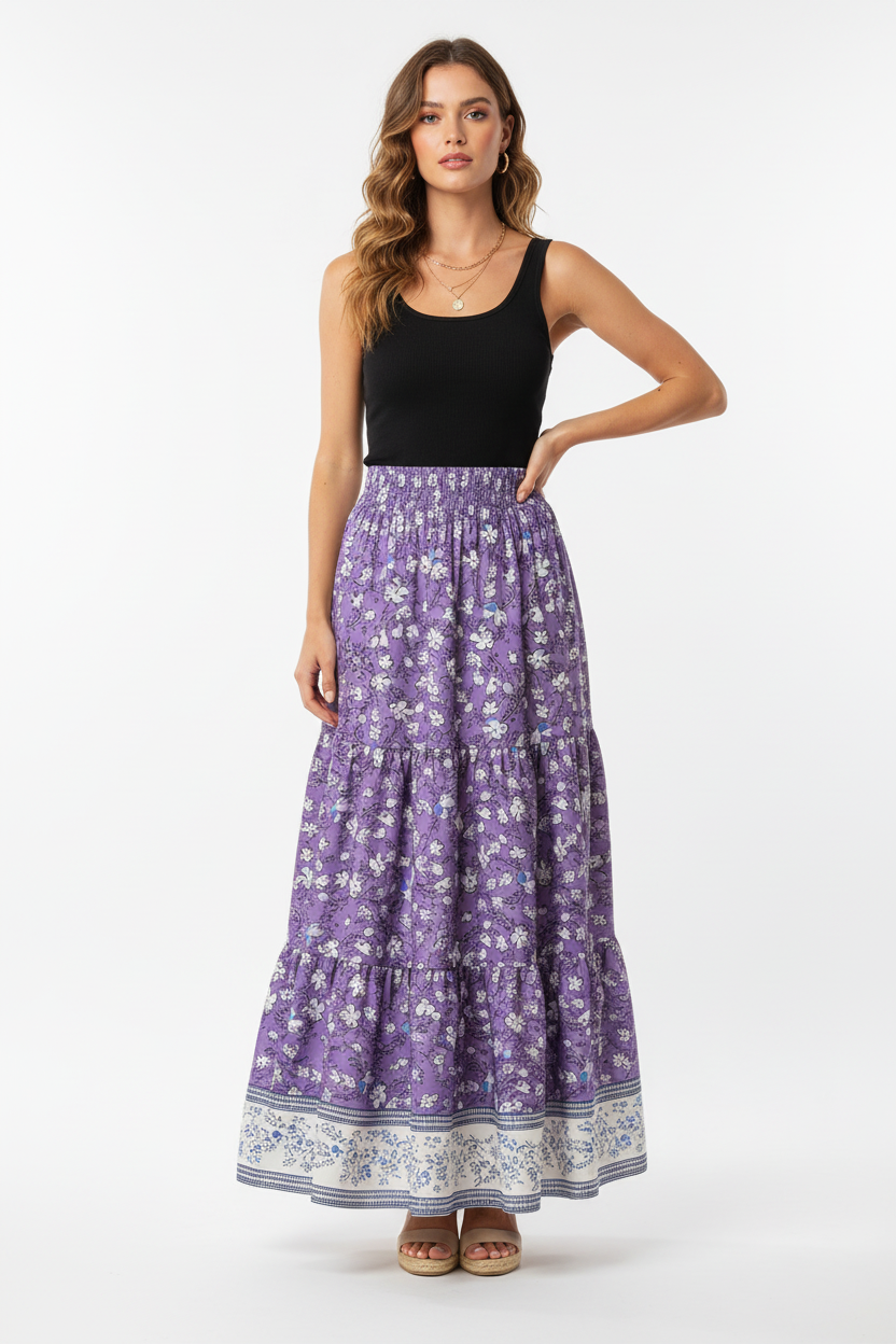 Jupe longue bohème Black-Coat à imprimé floral avec volants étagés et bordure contrastée - vue corps entier d'une mannequin avec main sur la hanche en pose confiante sur fond blanc studio, illustrant la silhouette bohème romantique, la longueur maxi flatteuse, les volants étagés qui ajoutent du volume et l'attitude décontractée et élégante que procure cette jupe