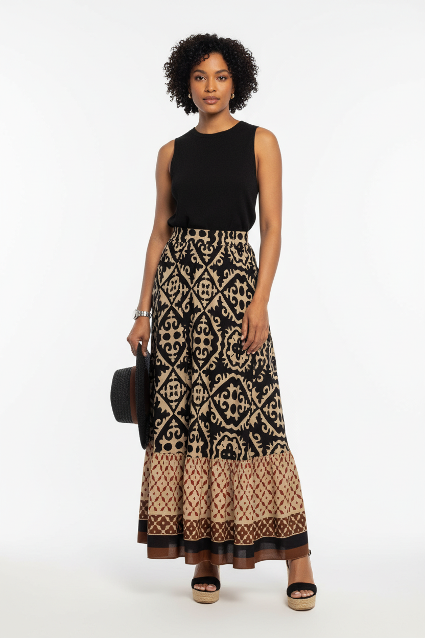 Jupe longue bohème Black-Coat noire et beige à imprimé géométrique avec volants étagés et bordure contrastée - vue de face frontale complète d'une mannequin en pose debout sur fond blanc studio, présentant la taille élastique confortable, les trois étages de volants superposés, l'imprimé géométrique noir et beige sophistiqué, la bordure décorative multicolore en bas et la longueur maxi fluide et bohème