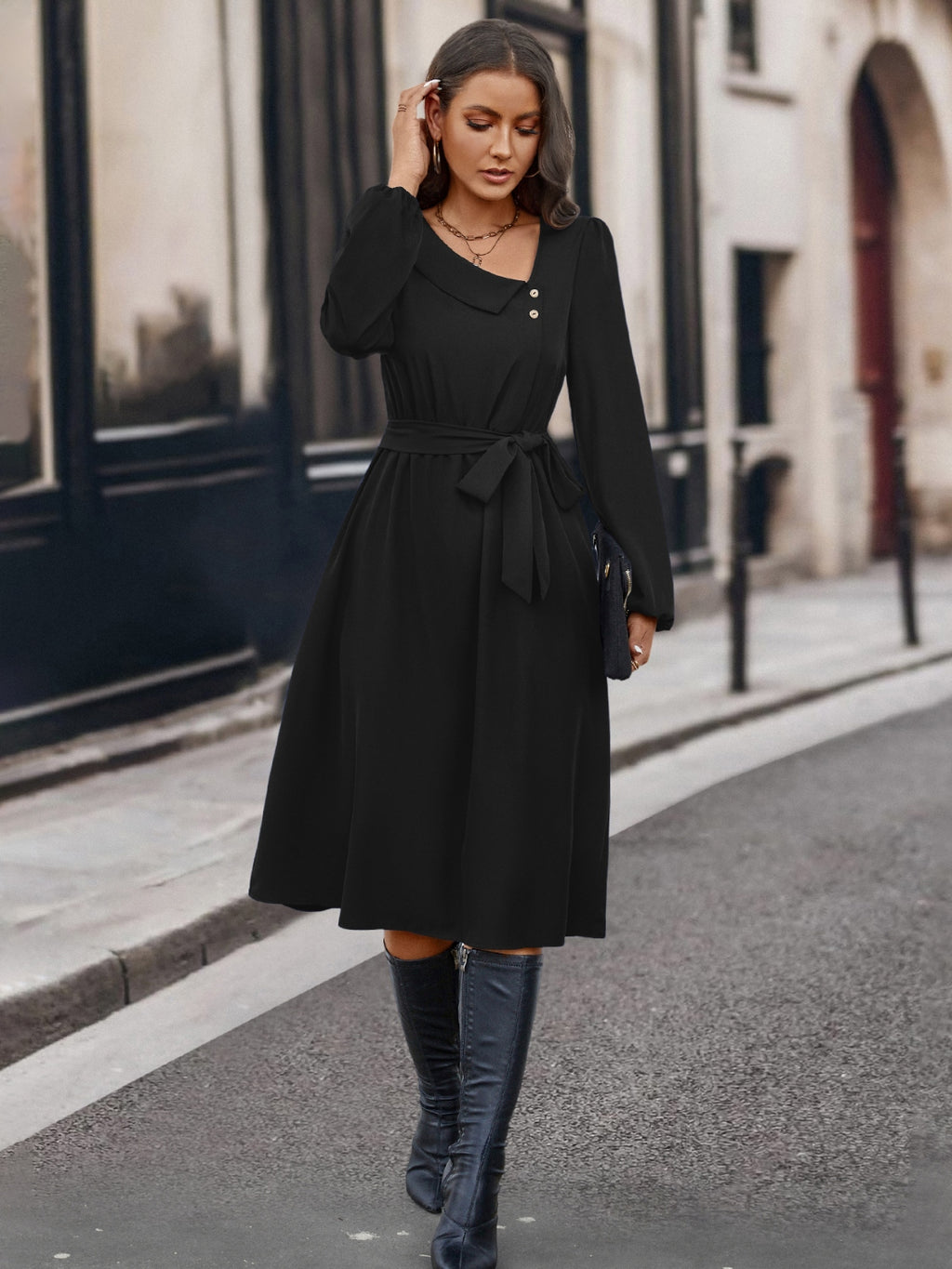 Robe asymétrique boutonnée BLACK-COAT - vue de profil révélant la coupe sculpturale flatteuse, le détail du col noué qui crée un point focal élégant, les manches longues sophistiquées et la silhouette moderne intemporelle
