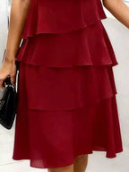 Gros plan détails : Robe grande taille rouge bordeaux manches pétales et volants - gros plan détaillé sur les manches pétales courtes délicates ajoutant touche féminine romantique, la texture luxueuse des volants étagés créant mouvement et dimension, et la qualité du tissu bordeaux profond sophistiqué - BLACK-COAT