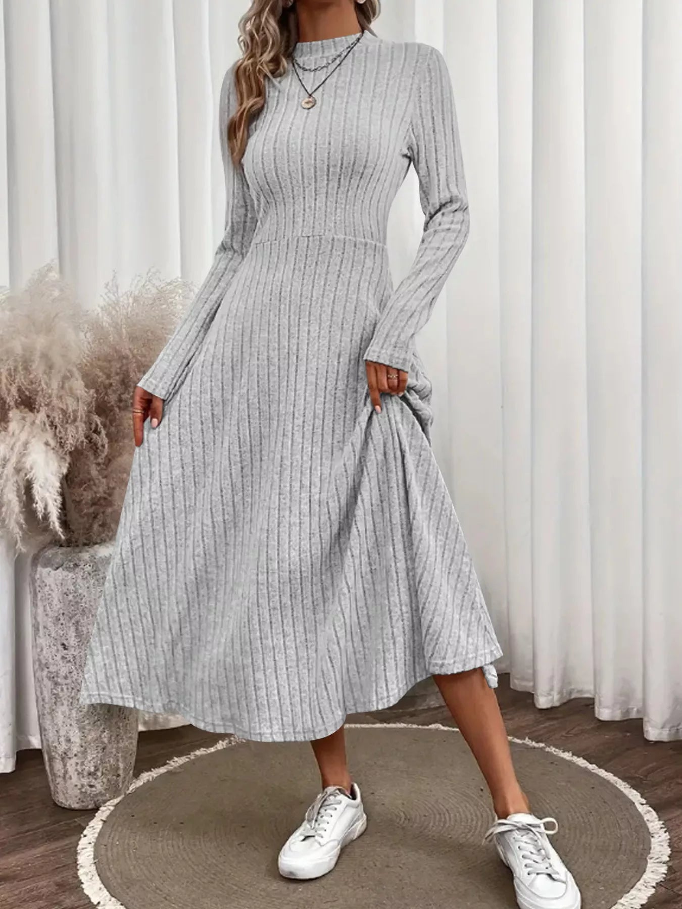 Robe midi femme silhouette A-line en tricot côtelé, texture nervurée verticale, coupe évasée trapèze, longueur midi, mélange coton polyester, corsage ajusté avec jupe évasée, vue de face montrant la texture côtelée et la forme A-line flatteuse
