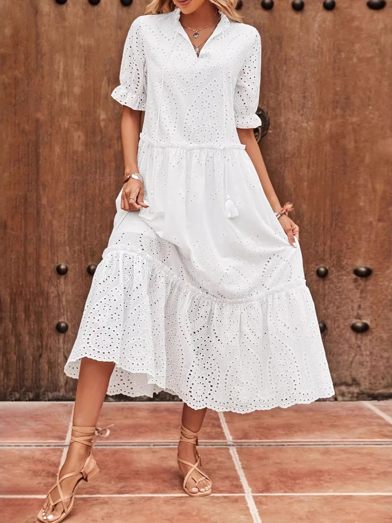 Robe midi en broderie anglaise avec encolure à nouer et demi-manches, détails eyelet délicats, encolure avec lien à nouer en ruban, manches mi-longues, longueur midi, vue de face montrant la broderie anglaise romantique et l'encolure à nouer
