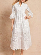 robe midi étagée broderie anglaise, encolure échancrée visible de côté, volants étagés superposés, détails eyelet, longueur midi fluide, silhouette romantique et féminine avec mouvement
