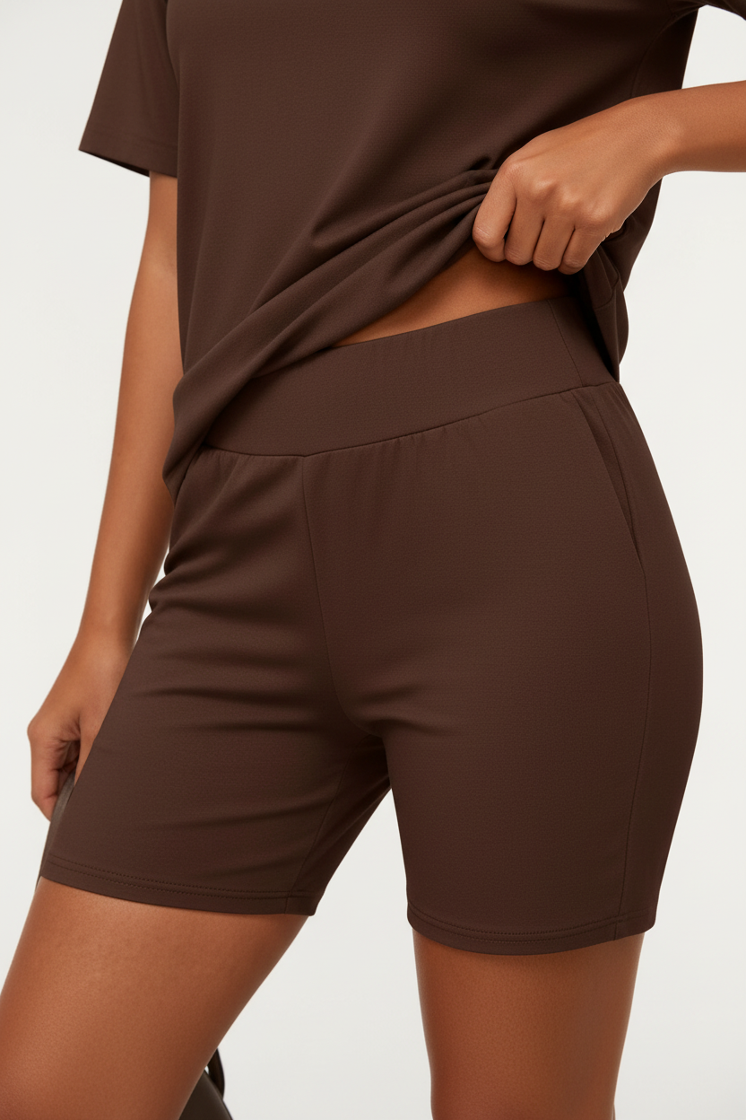 Mannequin de dos trois-quarts portant l'ensemble coordonné t-shirt oversize et short cycliste chocolat brun Black-Coat — coloris chocolat chaud et enveloppant d'une élégance naturelle, dos du t-shirt oversize tombant avec aisance et liberté, short cycliste gainant sublimant la silhouette arrière, ensemble monochrome chocolat créant une harmonie visuelle sophistiquée, fond blanc épuré, photographie mode éditoriale luxe accessible Black-Coat, une couleur qui s'accorde avec tout
