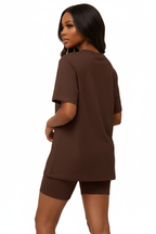  Mannequin de dos trois-quarts portant l'ensemble coordonné t-shirt oversize et short cycliste chocolat brun Black-Coat — coloris chocolat chaud et enveloppant d'une élégance naturelle, dos du t-shirt oversize tombant avec aisance et liberté, short cycliste gainant sublimant la silhouette arrière, ensemble monochrome chocolat créant une harmonie visuelle sophistiquée, fond blanc épuré, photographie mode éditoriale luxe accessible Black-Coat, une couleur qui s'accorde avec tout