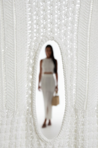 "Ensemble deux pièces crochet blanc - gros plan détail macro montrant le motif crochet ajouré complexe et raffiné, texture tricot artisanale, qualité du travail de maille, finition premium, fond blanc studio BLACK-COAT"