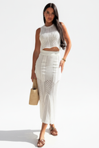 "Ensemble deux pièces crochet blanc - pose décontractée naturelle montrant la polyvalence de la tenue, crop top crochet col montant et jupe midi assortie, style casual chic, texture ajourée, fond blanc studio BLACK-COAT"