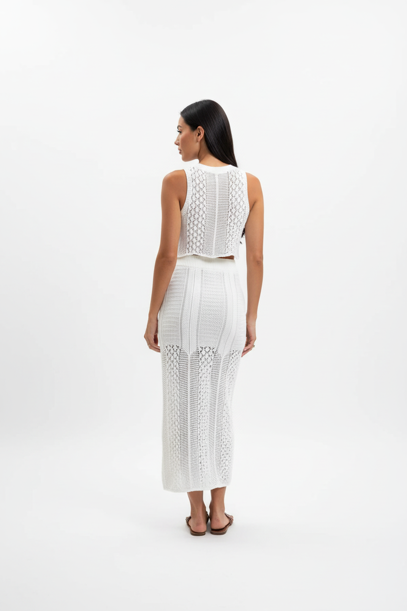 "Ensemble deux pièces crochet blanc - vue arrière dos montrant le design du dos du crop top crochet sans manches, motif tricot ajouré détaillé, jupe midi assortie, fond blanc studio BLACK-COAT"