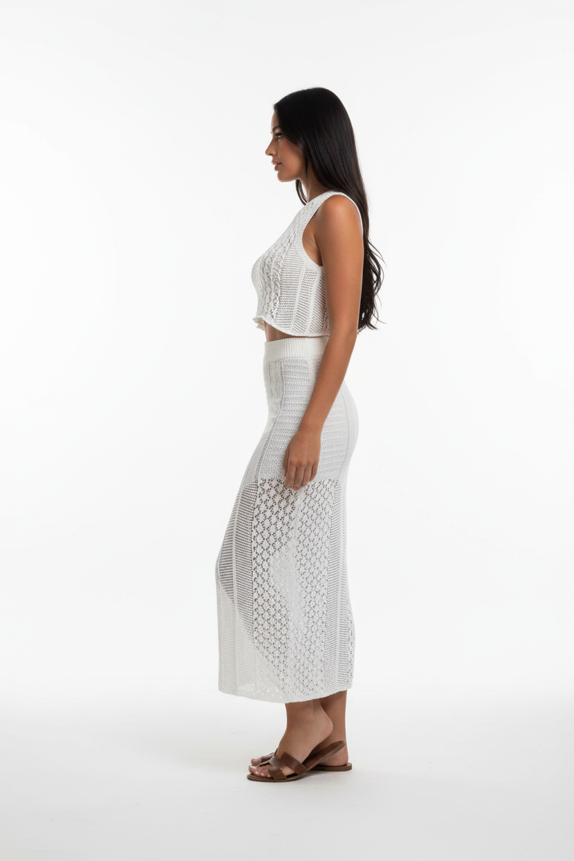  "Ensemble deux pièces crochet blanc - vue de profil latéral montrant la silhouette ajustée du crop top crochet et de la jupe midi, texture tricot ajouré visible, fente latérale de la jupe, fond blanc studio BLACK-COAT"