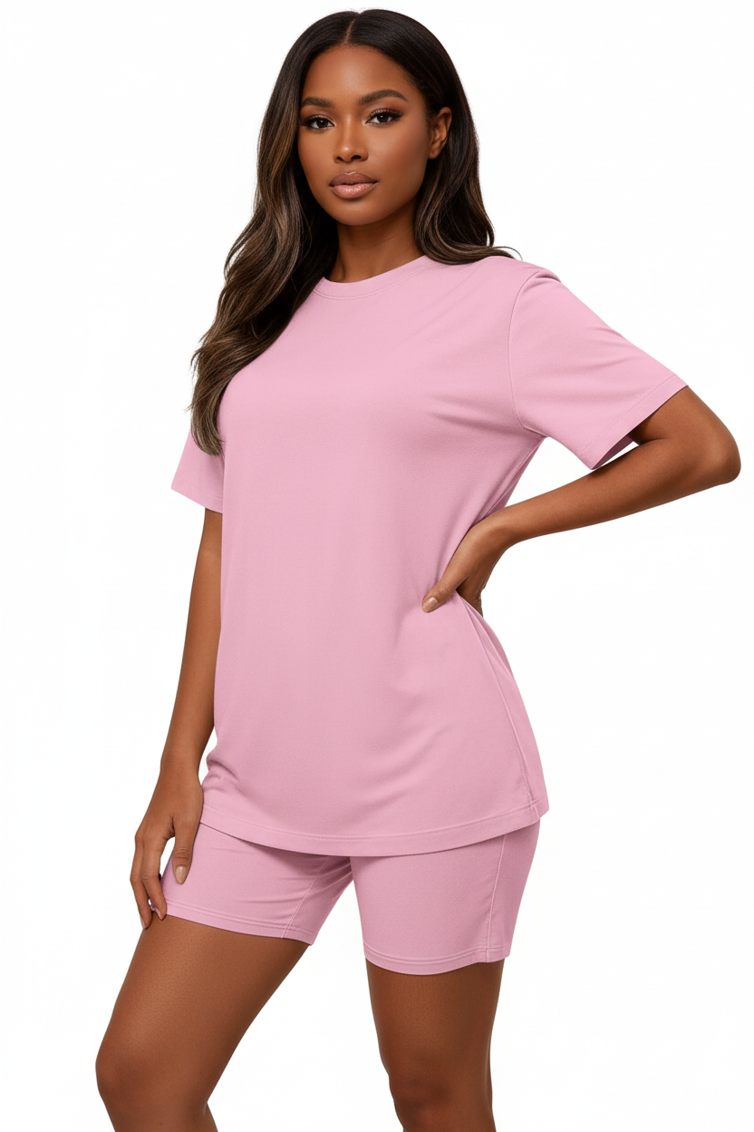  Mannequin en pose assurée main sur la hanche portant l'ensemble coordonné t-shirt oversize et short cycliste rose Black-Coat, vue trois-quarts — coloris rose doux et féminin apportant fraîcheur et bonne humeur, t-shirt oversize col rond au tombé parfait, manches courtes structurées, short cycliste gainant mettant en valeur la silhouette, ensemble monochrome élégant et moderne, fond blanc, photographie mode éditoriale contemporaine Black-Coat, de la salle de sport à la terrasse du café