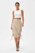 Jupe cargo beige avec poches latérales et cordons de serrage - pose en mouvement de face illustrant le confort et la praticité du vêtement - BLACK-COAT