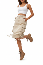 Jupe cargo beige avec poches latérales et cordons de serrage - pose dynamique en mouvement révélant la fluidité et l'amplitude de la jupe avec détails de cordons - BLACK-COAT