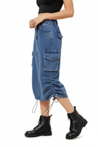 Jupe cargo en jean bleu mi-longue avec poches latérales et cordons de serrage - vue de profil révélant la poche cargo fonctionnelle et la longueur midi - BLACK-COAT

