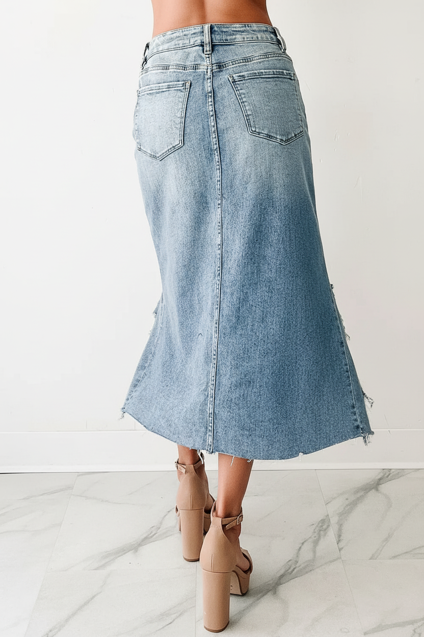 Vue arrière en mouvement : "Jupe midi en jean délavé bleu clair avec ourlet effiloché - vue arrière montrant le mannequin en mouvement avec finitions brutes et poches classiques - BLACK-COAT"