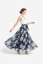 Jupe maxi imprimé floral bleu foncé avec ceinture à nouer - vue de profil opposé avec bras légèrement étendus montrant silhouette complète motif floral et longueur maxi élégante - BLACK-COAT