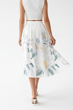 Jupe midi imprimé floral blanc boutonnée - vue arrière montrant mannequin s'éloignant avec taille élastique tissu floral fluide et flux élégant de la jupe midi - BLACK-COAT