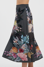 Jupe midi imprimée taille élastique noire avec motif floral artistique rose jaune bordeaux - gros plan de la taille aux cuisses montrant détails de la taille élastique confortable et motif floral artistique aux couleurs vibrantes sur fond noir avec mannequin en léger mouvement - BLACK-COAT