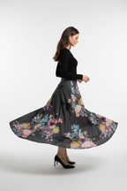 Jupe midi imprimée taille élastique noire avec motif floral artistique rose jaune bordeaux - vue de profil latéral capturant le mouvement de rotation dynamique avec tissu floral fluide et jupe midi tourbillonnant gracieusement - BLACK-COAT