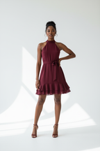  Mannequin portant la Robe Col Halter Ourlet Volants Black-Coat bordeaux - vue de face montrant le col halter, la ceinture et l'ourlet à volants