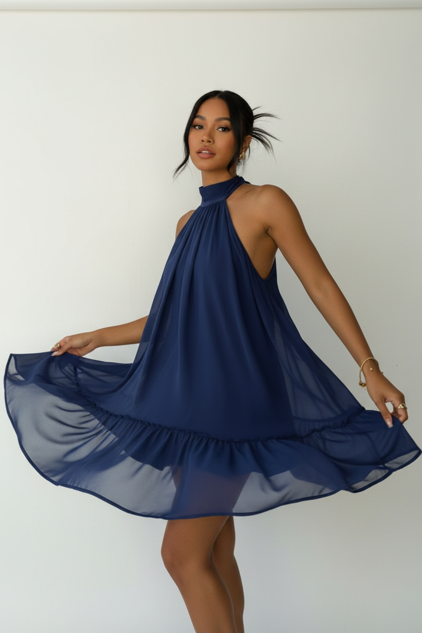 Robe mini halter Black-Coat bleu marine avec double volant - vue trois-quarts d'une mannequin en léger mouvement de rotation sur fond blanc studio, capturant la richesse de la couleur bleu marine profond, le mouvement fluide des deux étages de volants, la coupe halter élégante et la silhouette féminine moderne
