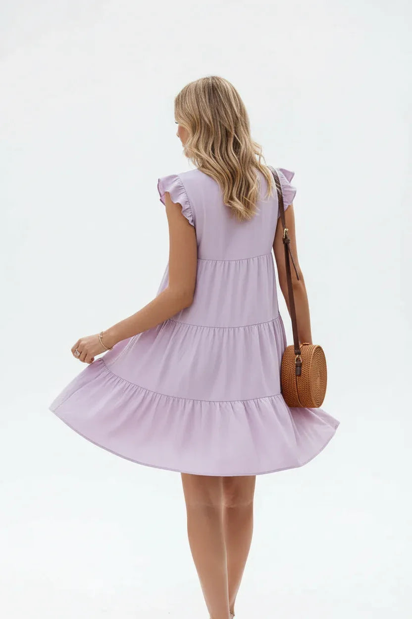 "Robe à volants étagés lilas avec manches papillon - vue arrière trois-quarts en marche montrant les détails du dos et le flux des volants - BLACK-COAT"