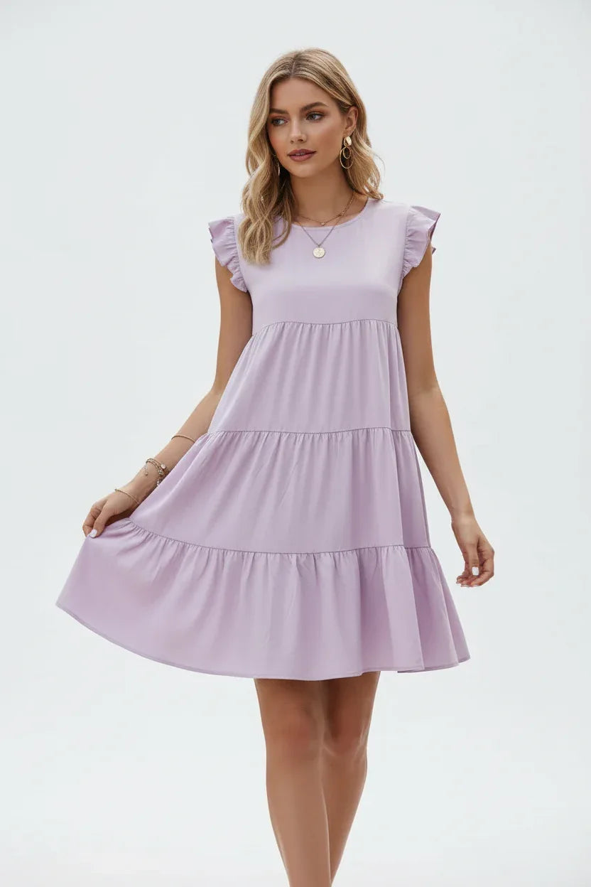 "Robe à volants étagés lilas avec manches papillon - pose élégante avec main touchant les volants montrant les détails de construction - BLACK-COAT"