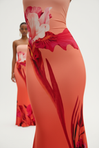 "Robe maxi bodycon bustier imprimé floral corail rouge - gros plan détail imprimé floral montrant les grandes fleurs rouges roses audacieuses, dégradé de couleur corail orange vibrant, qualité impression tissu, motif floral artistique sophistiqué, fond blanc studio BLACK-COAT"