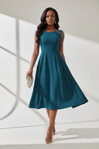 : Robe Midi Sans Manches Détails Perles Black-Coat bleu paon - vue en marche illustrant l'élégance sophistiquée et l'allure confiante