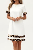 Robe mini col rond imprimé léopard blanche - gros plan du bas de robe de la taille aux cuisses montrant bandes horizontales imprimé léopard à l'ourlet en mouvement et silhouette mini flatteuse - BLACK-COAT