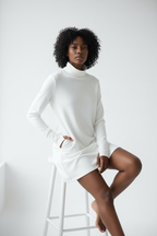  Robe Mini Col Roulé Black-Coat blanche - pose assise montrant le drapé confortable et la polyvalence de la robe