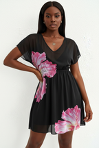  Mannequin portant la Robe Mini Imprimée Black-Coat noire avec grande fleur rose - vue de face montrant le décolleté en V et la taille froncée