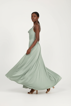 Robe maxi satin vert sauge Black-Coat - vue de profil avec mannequin  révélant la fente latérale élégante et le tombé fluide du satin, style chic abordable
