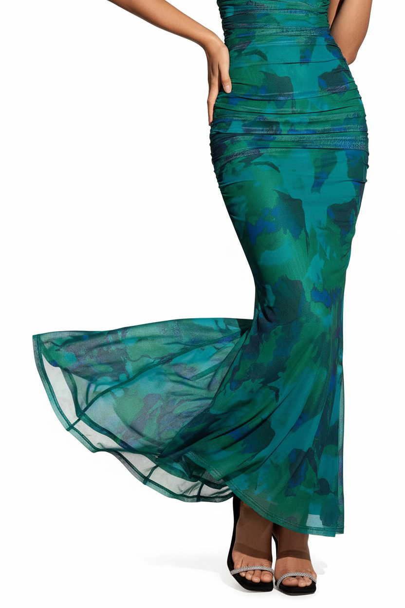 "Robe sirène maxi émeraude épaules dénudées froncée - gros plan détail ourlet sirène évasé montrant le bas de la robe qui s'évase élégamment, fluide du tissu, design mermaid sophistiqué, motif vert émeraude, fond blanc studio BLACK-COAT"