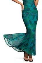 "Robe sirène maxi émeraude épaules dénudées froncée - gros plan détail ourlet sirène évasé montrant le bas de la robe qui s'évase élégamment, fluide du tissu, design mermaid sophistiqué, motif vert émeraude, fond blanc studio BLACK-COAT"