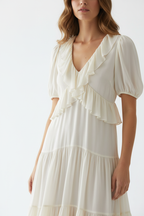  "Robe étagée encolure crantée manches courtes BLACK-COAT - gros plan haut du corps montrant détail de l'encolure crantée distinctive, finition des manches courtes et première couche étagée, mannequin en léger mouvement sur fond blanc studio"